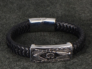 Detailed macro view of woven leather men's bracelet featuring masonic symbol buckle