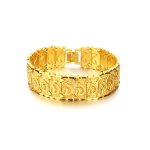 Macro detail of 18K gold plated wide bracelet with embossed dragon pattern texture