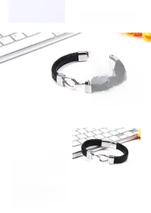 Detail of men's black braided leather bracelet with silver horseshoe U-shaped buckle clasp