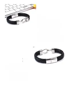 Detail of black braided leather bracelet with silver horseshoe magnetic metal clasp