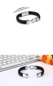 Detailed macro view showing the silver U-shaped magnetic clasp on a black woven leather bracelet