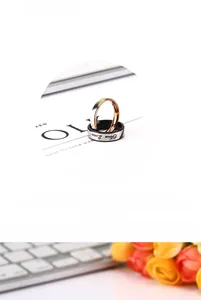 Detail of titanium steel couple rings set with black True Love engraving and gold finish