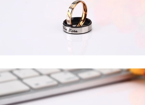 Macro shot of titanium steel couple rings with True Love engraving and small inset crystal