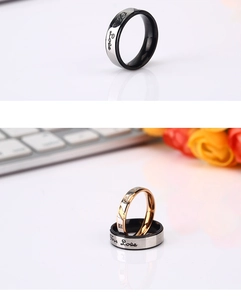 Close-up of tricolor titanium rings with Love engraving and a small square diamond