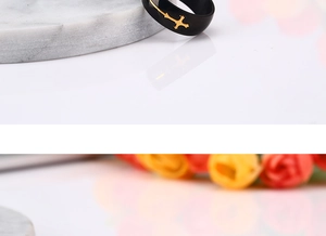 Detail shot of black matte men's ring with engraved golden cross in religious style