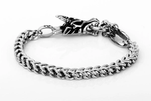 Close-up of vintage silver dragon head bracelet with detailed braided metal links
