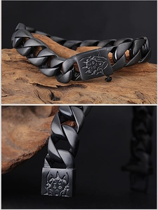 Détail du bracelet punk en titane noir mat avec gravure de crâne et flamme sur le fermoir