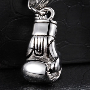 Pendentif gant de boxe en acier inoxydable argenté sur fond texturé de crocodile noir