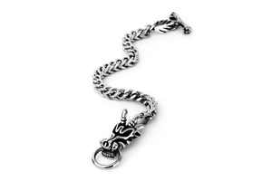 Detail macro view of vintage dragon head clasp on woven stainless steel chain bracelet