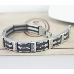 Macro shot of silver steel links with cross diamond patterns on a black rubber band