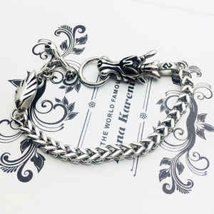 Detailed view of silver dragon head clasp and wheat chain on stainless steel bracelet