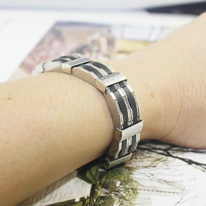 Close-up of a men's silicone and titanium steel bracelet with geometric X patterns