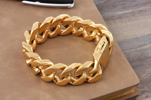 Detail of chunky gold titanium steel Cuban link bracelet with a secure square clasp