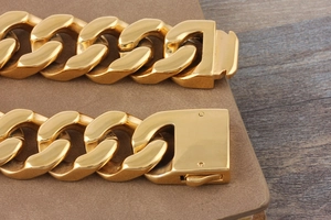 Close-up of thick gold-plated stainless steel Cuban link bracelet with a secure buckle