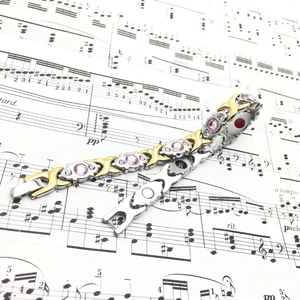 Détail macro du bracelet magnétique bicolore avec pierre rose et cristaux blancs