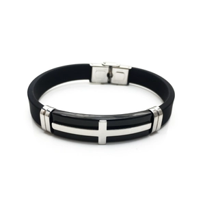 Detail of cross-shaped stainless steel ornament on a flexible black silicone bracelet