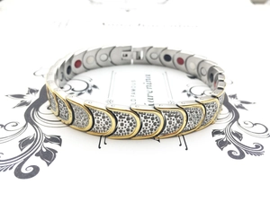 Macro view of two-tone magnetic therapy bracelet with scale texture and embedded stones