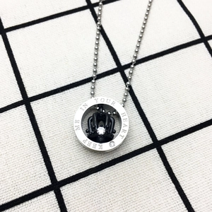 Detail of crown pendant with black finish, clear zircon and engraved circular ring
