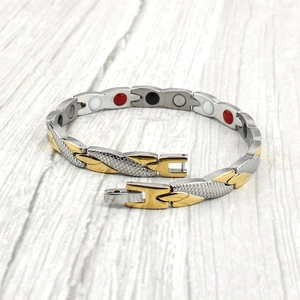 Détail macro du bracelet magnétique bicolore avec motif écailles de poisson gravé sur acier