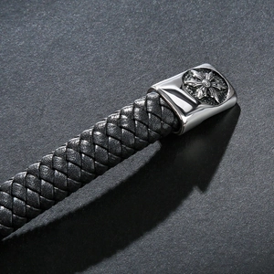 Detail eines schwarzen Lederarmbands mit silbernem Metallverschluss und Kreuzstern