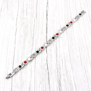 Bracelet magnétique en acier inoxydable argenté avec pierres de santé sur fond bois
