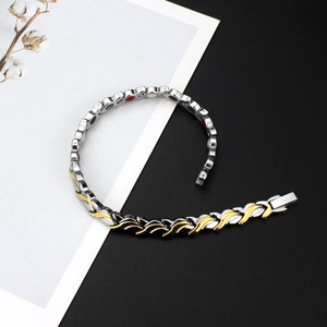 Bracelet magnétique bicolore argent et or avec motif tressé sur fond noir et blanc