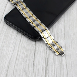 Men's magnetic stainless steel bracelet with silver and gold links on a smartphone