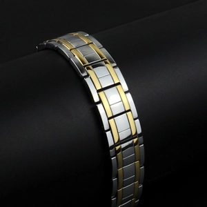 Men's magnetic stainless steel bracelet in two-tone silver and gold finish on a display