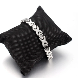 Titanium steel magnetic bracelet for women featuring silver X-link design on black pillow