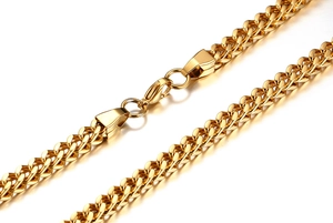 Détail d'une chaîne épi dorée avec fermoir mousqueton sur collier en acier inoxydable