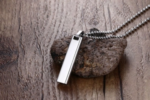 Close-up of a polished stainless steel rainbow rectangle pendant on a silver ball chain