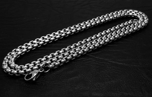 Titanium steel interlocking circle necklace with lobster clasp on black leather background