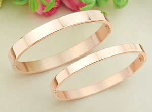 Detailed view of rose gold stainless steel couple bracelets with mirror polished finish