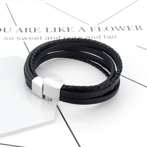 Bracelet multi-rangs en cuir noir tressé avec fermoir magnétique argenté sur fond blanc