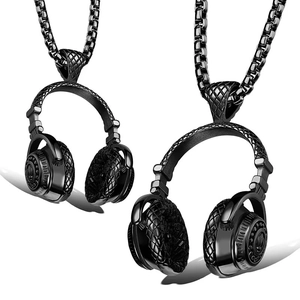 Détail macro du pendentif casque noir avec texture losange et chaîne box en acier