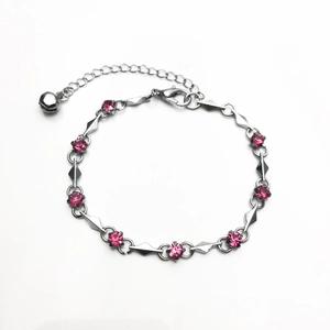 Silver geometric link bracelet with pink zircon crystals and a small bell charm