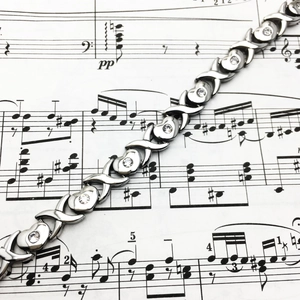 Bracelet à maillons cœur et X en acier poli avec zircon blanc sur partition de musique