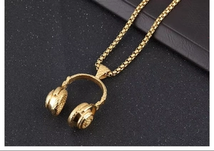 Vue détaillée du pendentif casque doré avec texture maillée sur une chaîne box