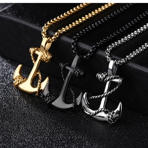 Detailed macro view of anchor pendants in gold, black, and silver finish on jewelry stand