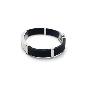 Detailed close-up of a men's black rubber bracelet with silver stainless steel pattern