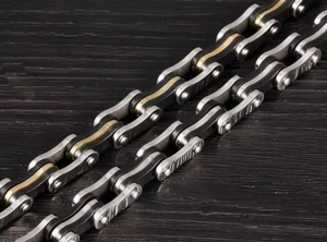 Macro shot of mechanical industrial style bicycle chain bracelet with gold accents