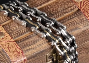 Macro view of mechanical style stainless steel bicycle chain bracelet on wooden chest
