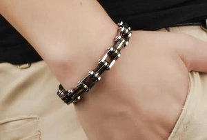Close-up of industrial bicycle chain bracelet in silver gold and black titanium steel
