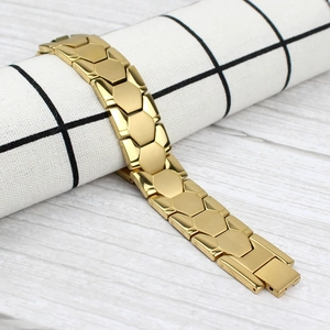 Macro detail of gold-plated stainless steel men's bracelet with hexagonal links and fold-over clasp