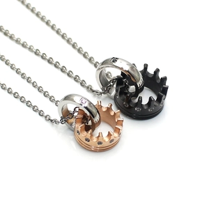 Close-up of interlocking crown rings necklaces with zircon stones on silver chains