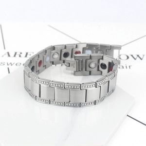 Detailansicht eines silbernen H-Glied Magnettherapie Armbands auf weißem Marmor