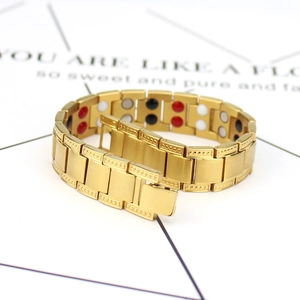 Men's wide magnetic gold steel bracelet with multicolored therapy stones on white background