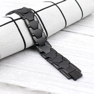 Industrial black titanium steel magnetic bracelet for men with geometric links on wood