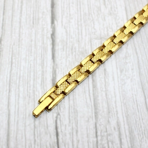 Bracelet magnétique doré pour femme avec des maillons texturés à motif d'écailles