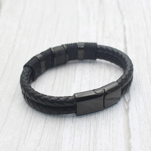 Detail of men's double-braid leather bracelet with magnetic clasp and knurled metal ring